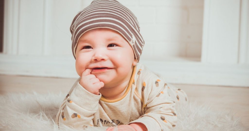 l'immagine mostra un bimbo di qualche mese alle prese con i primi dentini, dentizione decidua